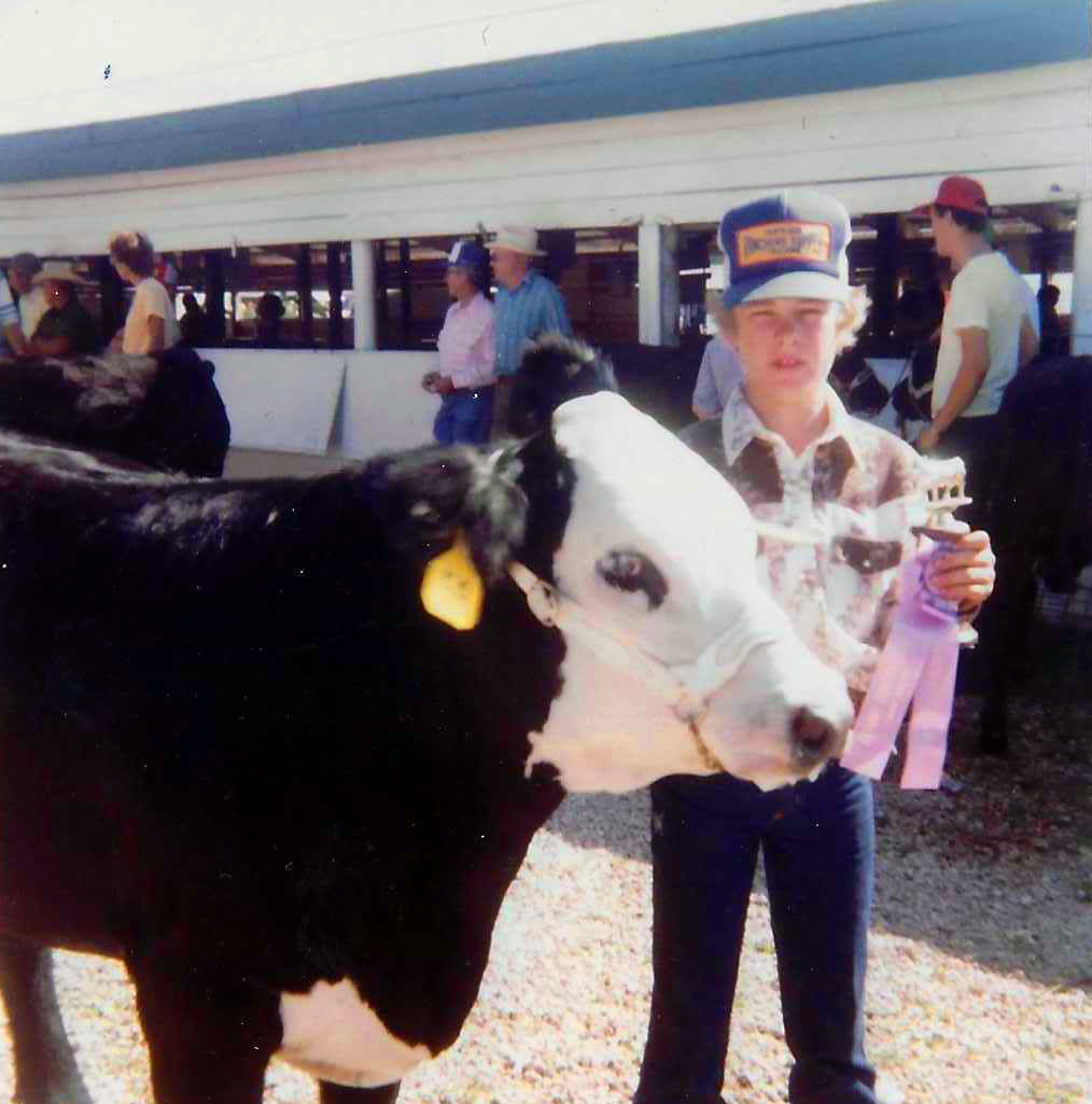 kid showing a cow