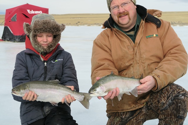 two people with fish from ice fishing